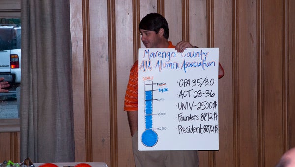Marengo County Auburn Club president Sean Parker holds a poster showing the club's progress toward their scholarship.