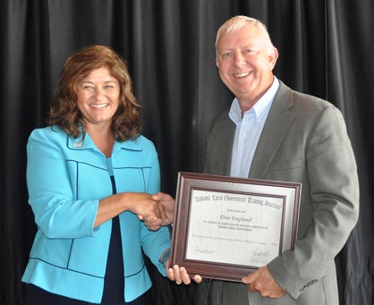 Debbie Wood, president of the Association of County Commissions of Alabama, congratulates Commissioner Dan England on his graduation from the Alabama Local Government Training Institute.