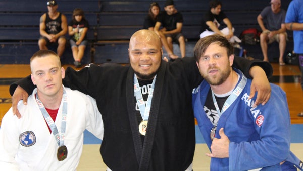 Ross Martial Arts grappler Tony Nicholson, center, won first place in the white belt absolute division and second place in the white belt men’s heavyweight gi competition at the Alabama Brazilian Jiu Jitsu Federation’s Summer Championships in Birmingham.