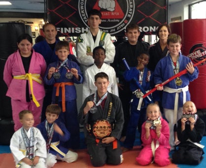 Members of the Ross Martial Arts junior Brazilian jiu-jitsu team are shown with awards they won at the Georgia state championships in Atlanta in July. Shown from left to right are: first row - Dylan Russell, Braden Morgan, Brett Schroeder, Joanna Duke and Charlie Duke; second row - Bebe Ellis, Collin Morgan, Milan Wallace, Dyllon Williams and Will Cork; back row - Jay Russell, Tristen Fitz-Gerald, Hunter Compton and Ronda Russell. Not pictured is Austin Wright.
