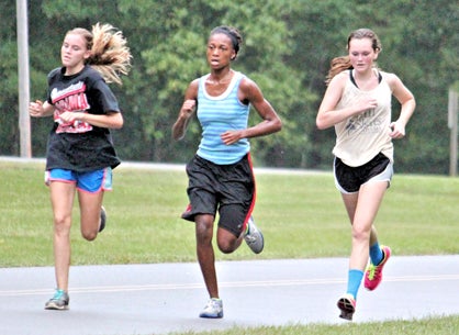 Audrey Boykin, Darnesha Harris and Mary-Michael Bradley run during a rainy practice Monday.