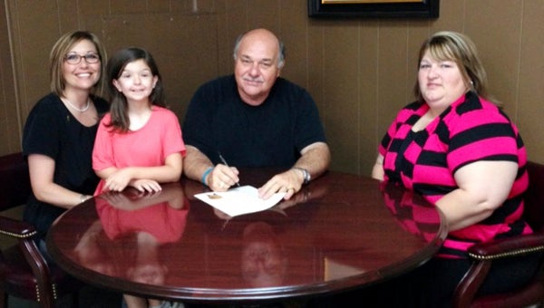 Jennifer Thomason, Anna-Coleman Yelverton and Dena Smith are shown with Demopolis Mayor Mike Grayson as he signs a proclamation to make September Childhood Cancer Awareness Month in Demopolis.