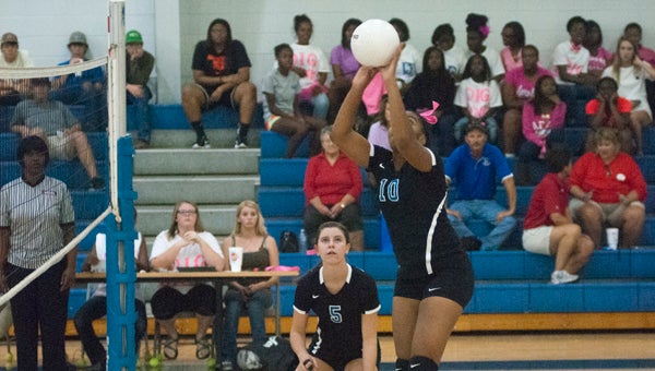 Ivery Moore tips the ball over the net in Demopolis' match against Linden on Monday.