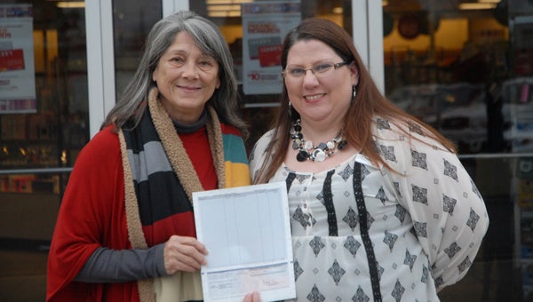 Harriet's House Director Susanna Naisbett receives a check from Demopolis Goody's Store Manager Julie Pepper.