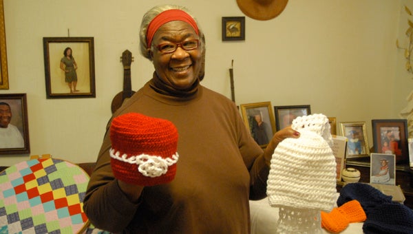 Sara Smith shows off a few of her creations, which she calls "God's gifts of creation." Smith said for 2015, she wants to bless those who are in nursing homes by making them caps, dress hats, scarves, bedroom slippers and more.