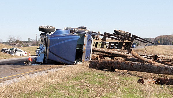 A truck carrying a load of logs spilled over into the median on Hwy. 80, west of Demopolis Tuesday morning after colliding with another vehicle. Both drivers were taken to the hospital with injuries.