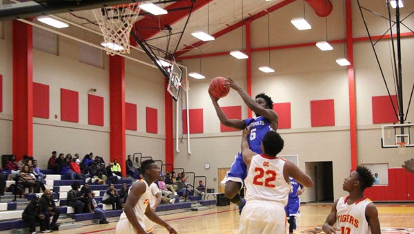 Xavier Jowers soars to the rim against Greene County. Jowers led the Tigers with 15 points. 