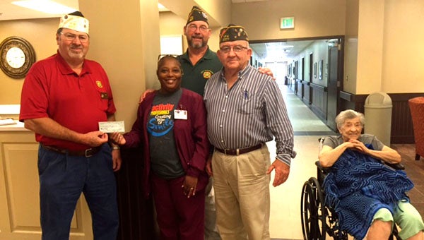 Luther Massey, VFW Post 5377 Quartermaster, presents a donation to a staff member of Bill Nichols State Veterans Home alongside Phillip Spence, Post Surgeon (back) and Doug Null, Adjutant.